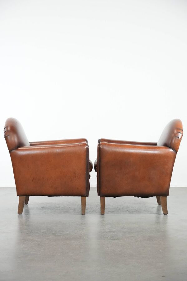 Ensemble de 2 fauteuils en peau de mouton au design art déco avec des couleurs chaudes.