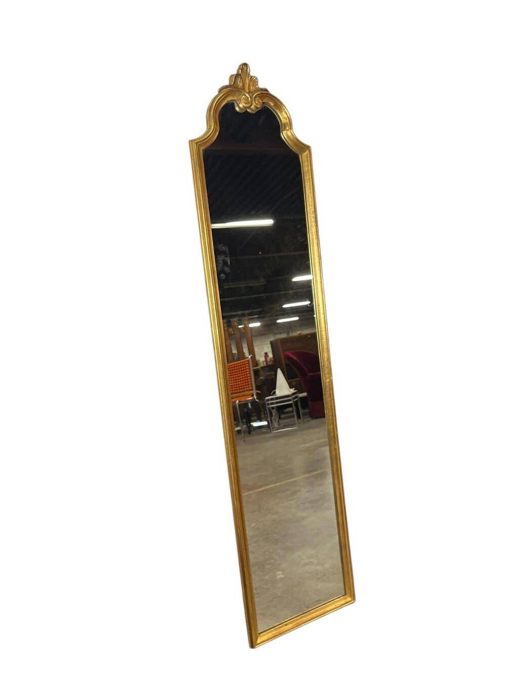 Narrow and tall antique mirror, adorned with golden patterns.