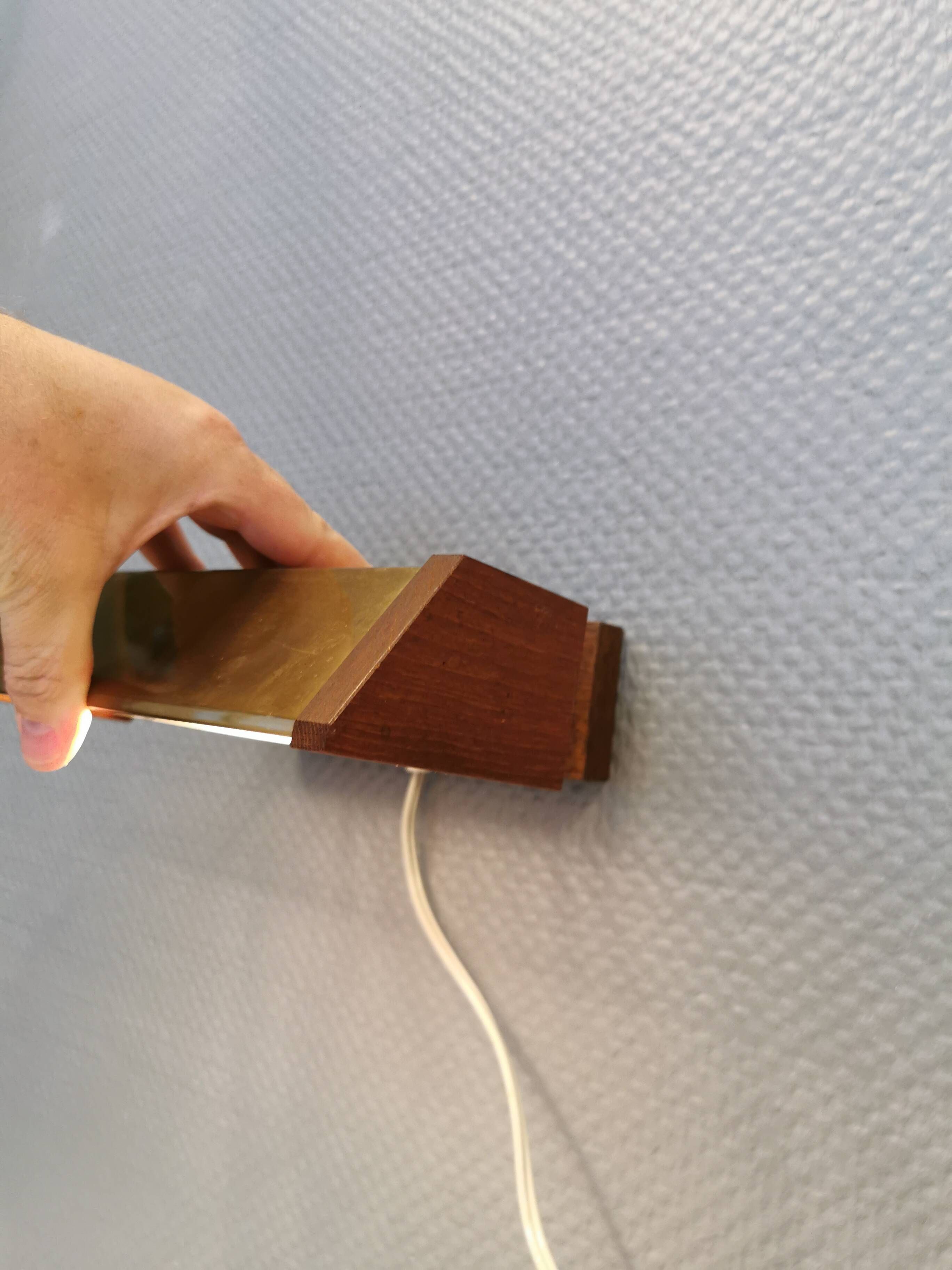 Fuga wall lamp in solid brass and teak wood was designed by Jo Hammerborg for Fog & Mørup in 1966.