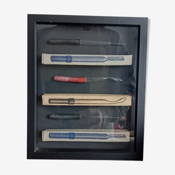 Showcase frame with old glass medical pipettes