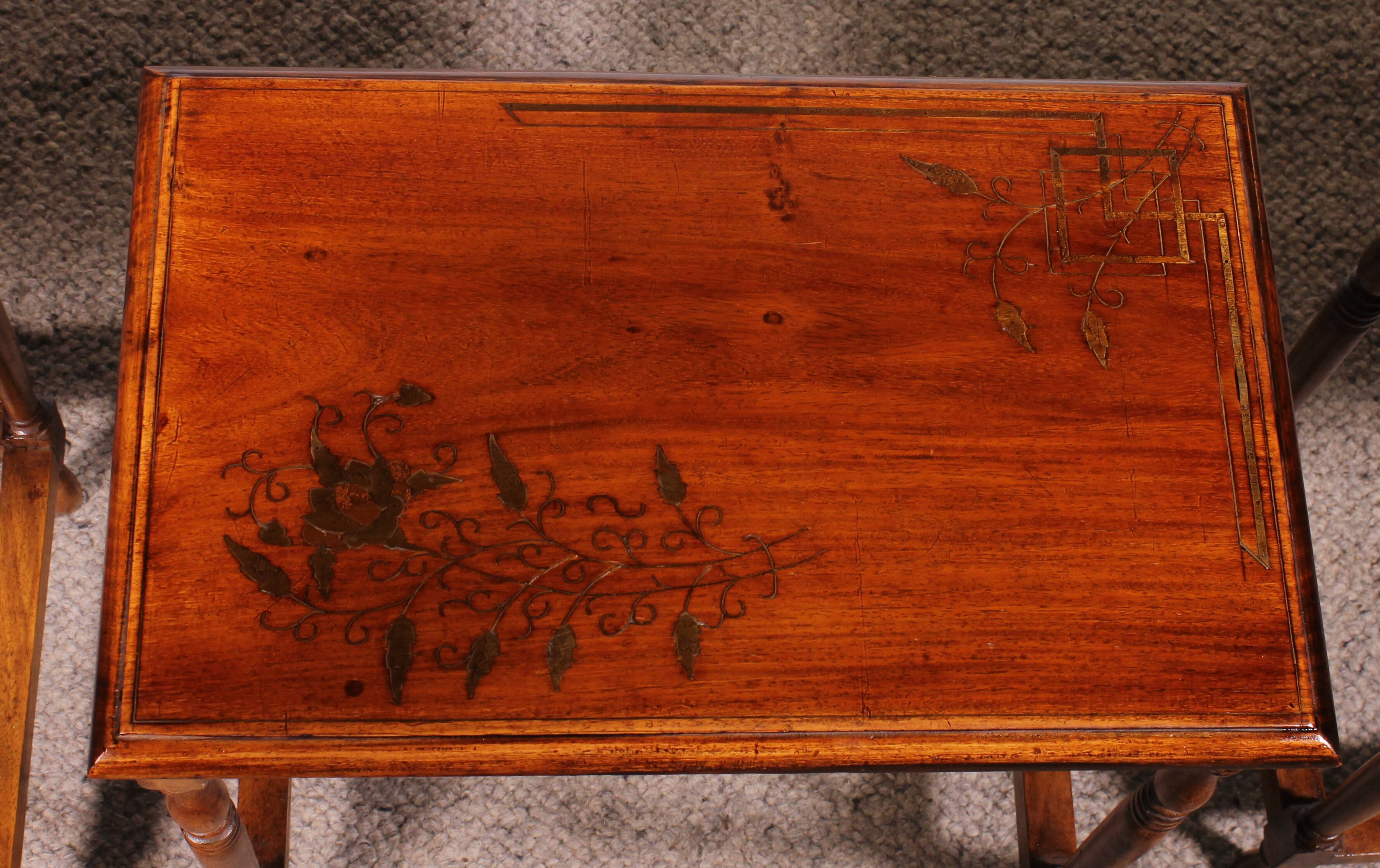 Nested tables in satin wood with brass inlays.