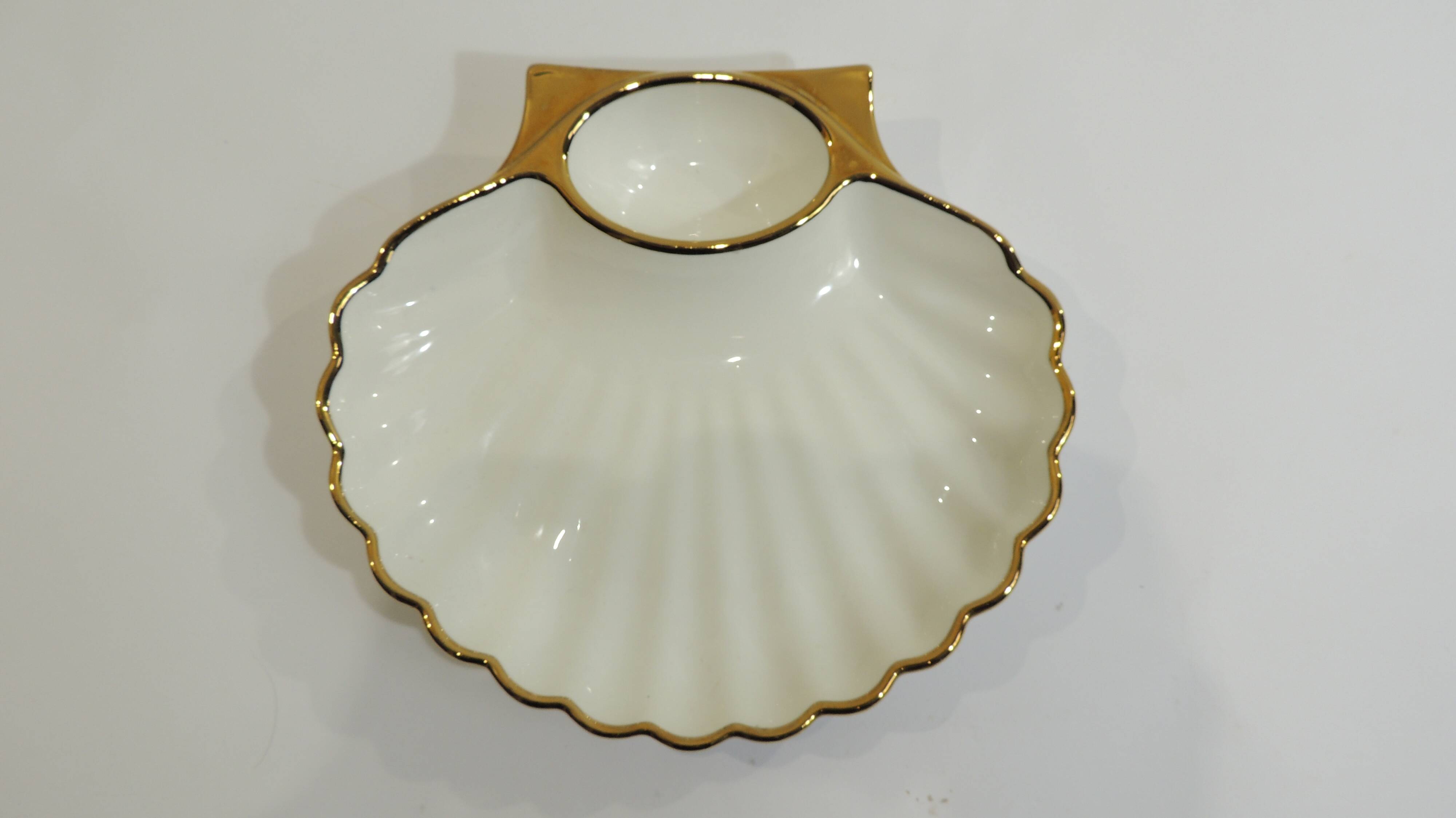 Shell-shaped porcelain pocket bowl from Queen’s Porcelain, with a gold rim.