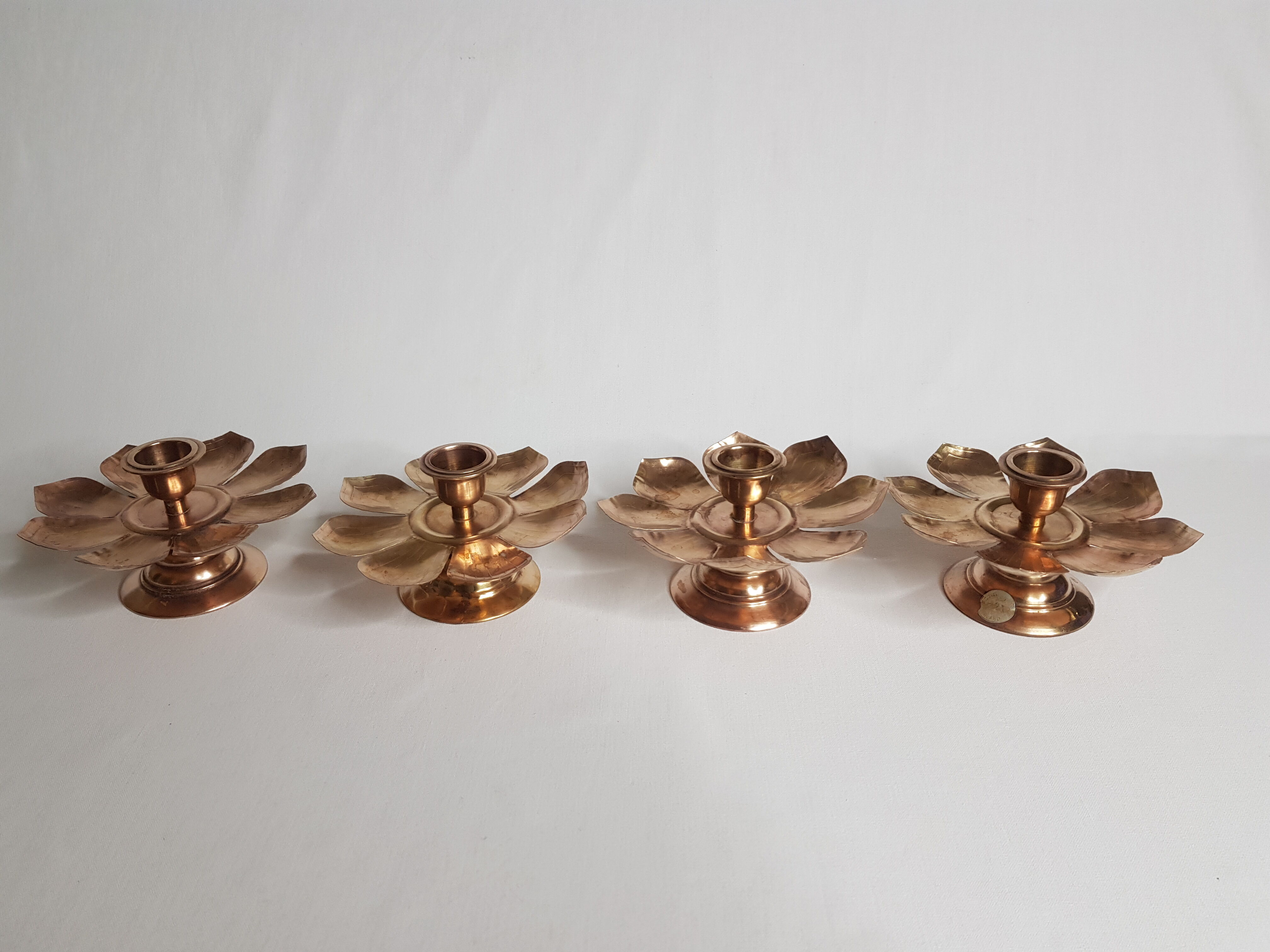 Set of four copper candlesticks in the shape of lotus flowers