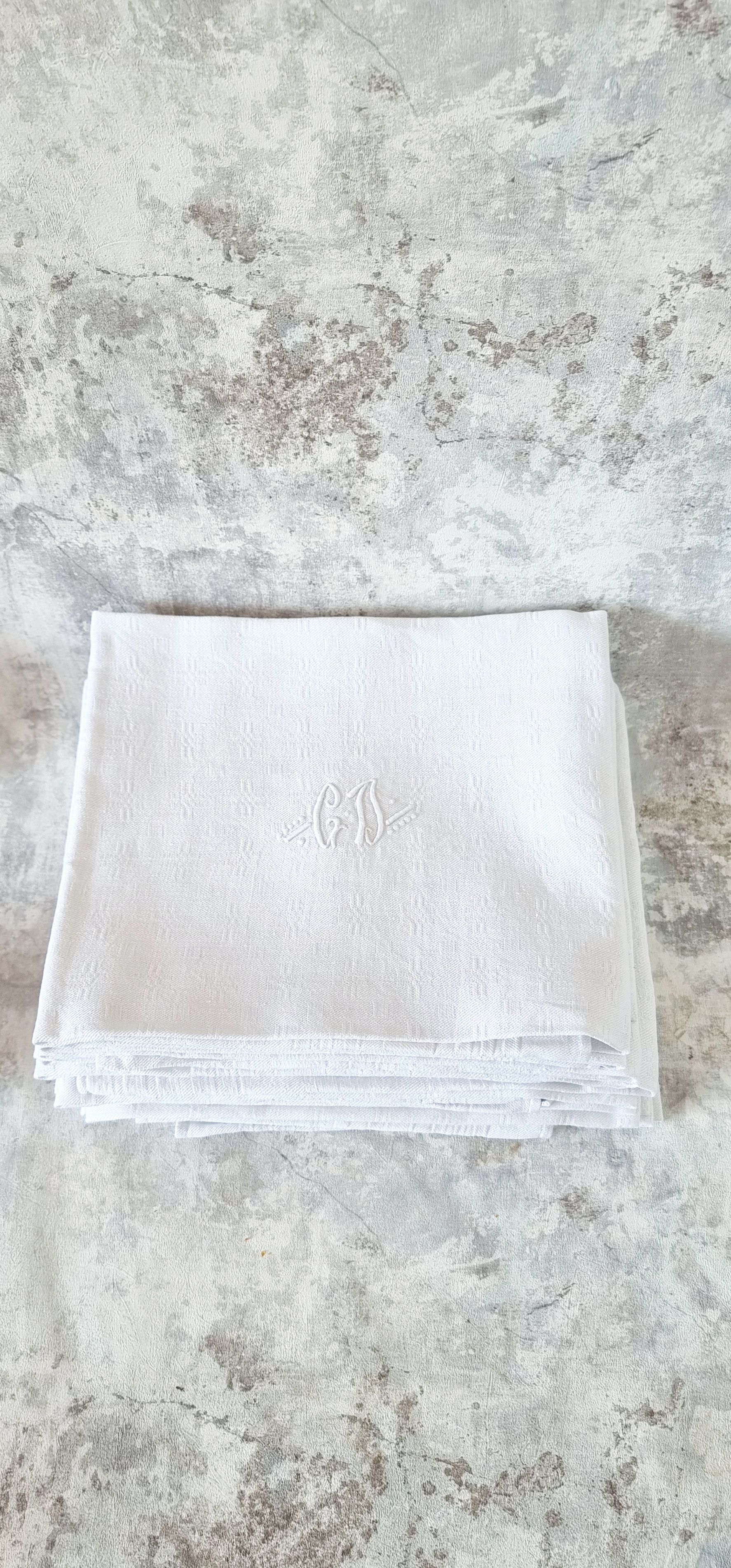 12 antique French linen towels with damask embroidery with "GB" anagrams.