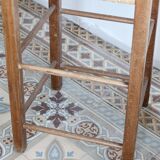 Vintage wooden high chair for children with a straw seat.