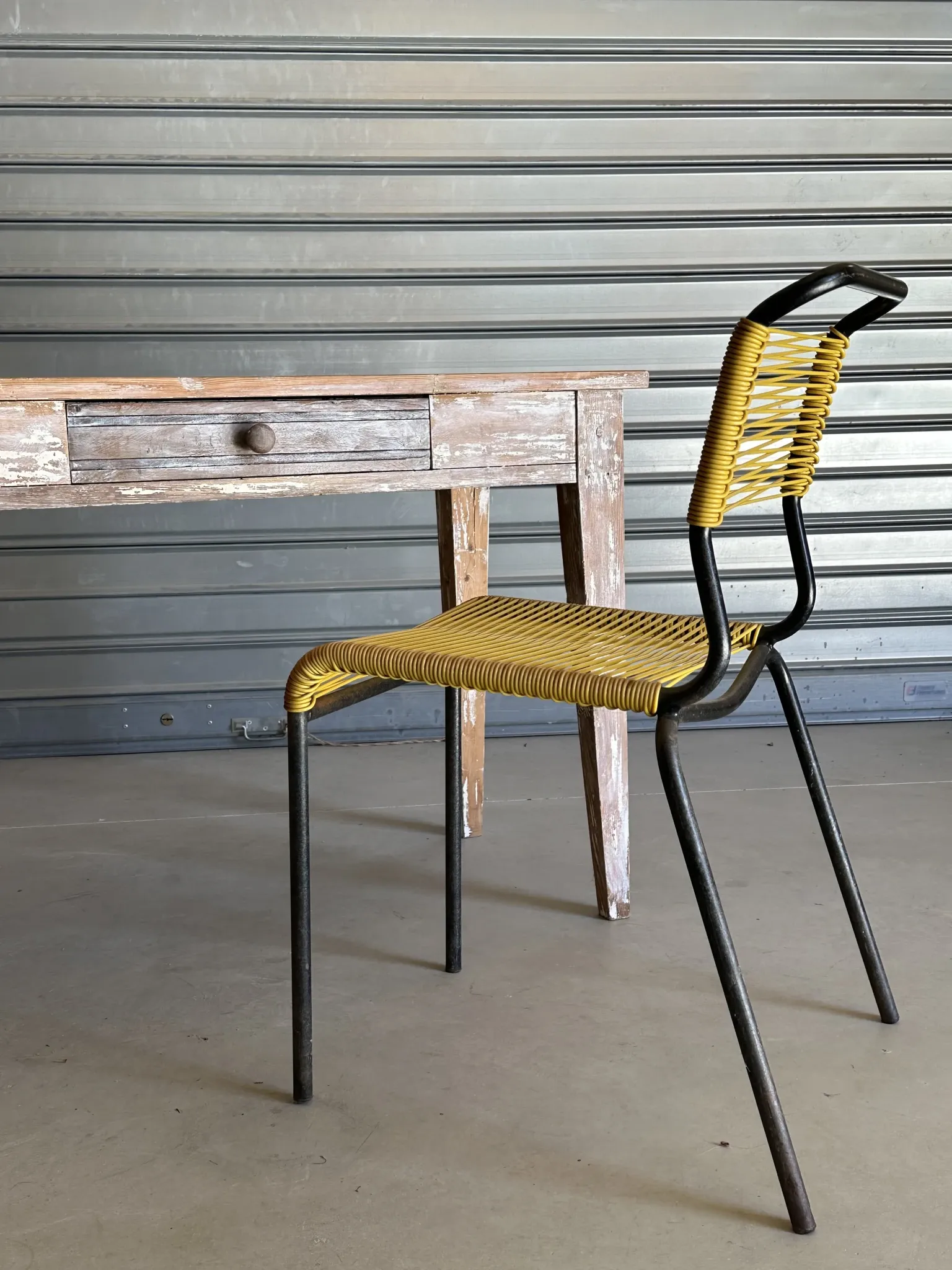 Vintage table made of raw wood with a distressed white base.