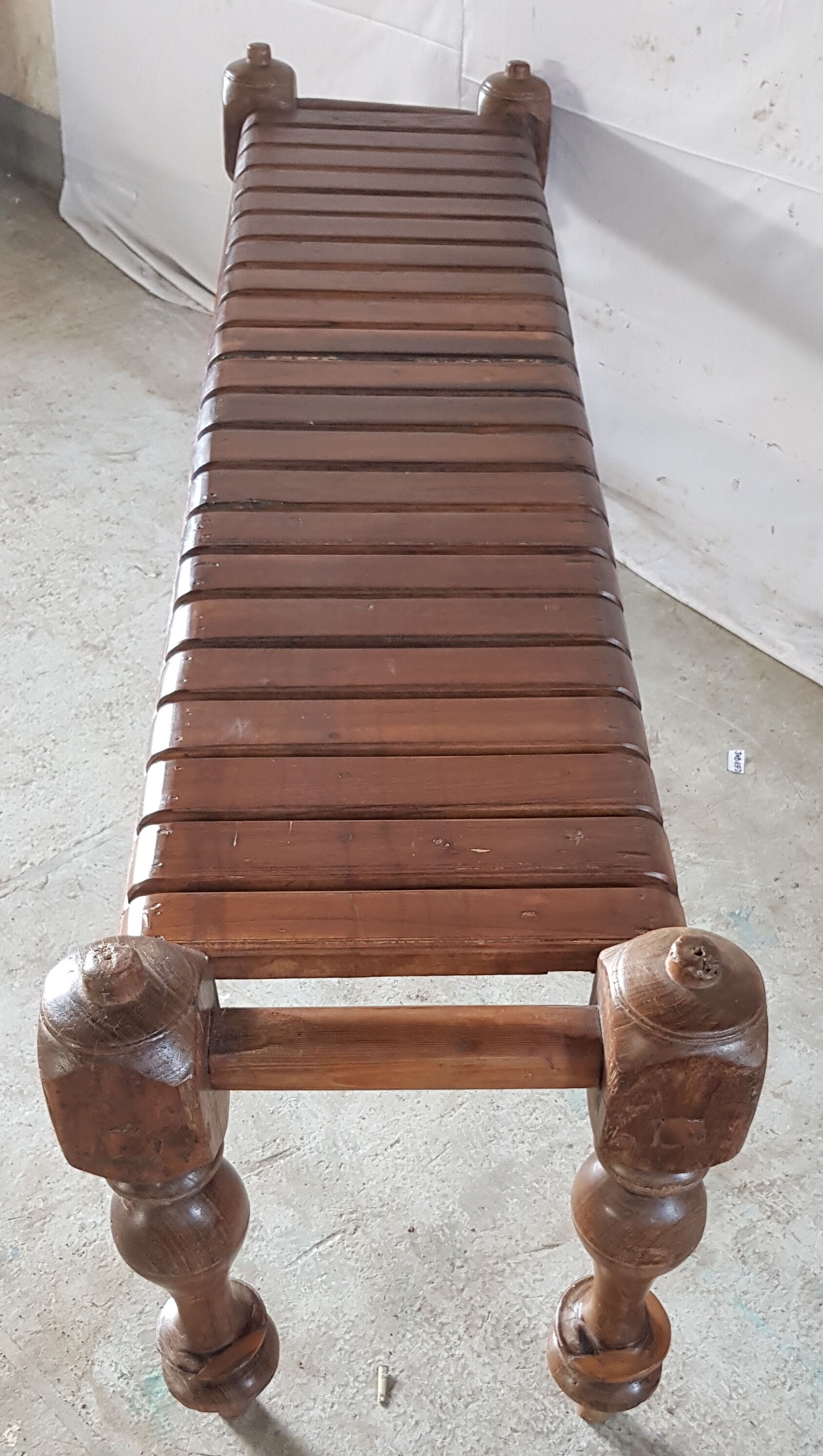 Bench with slats and feet of charpoy beds in teak