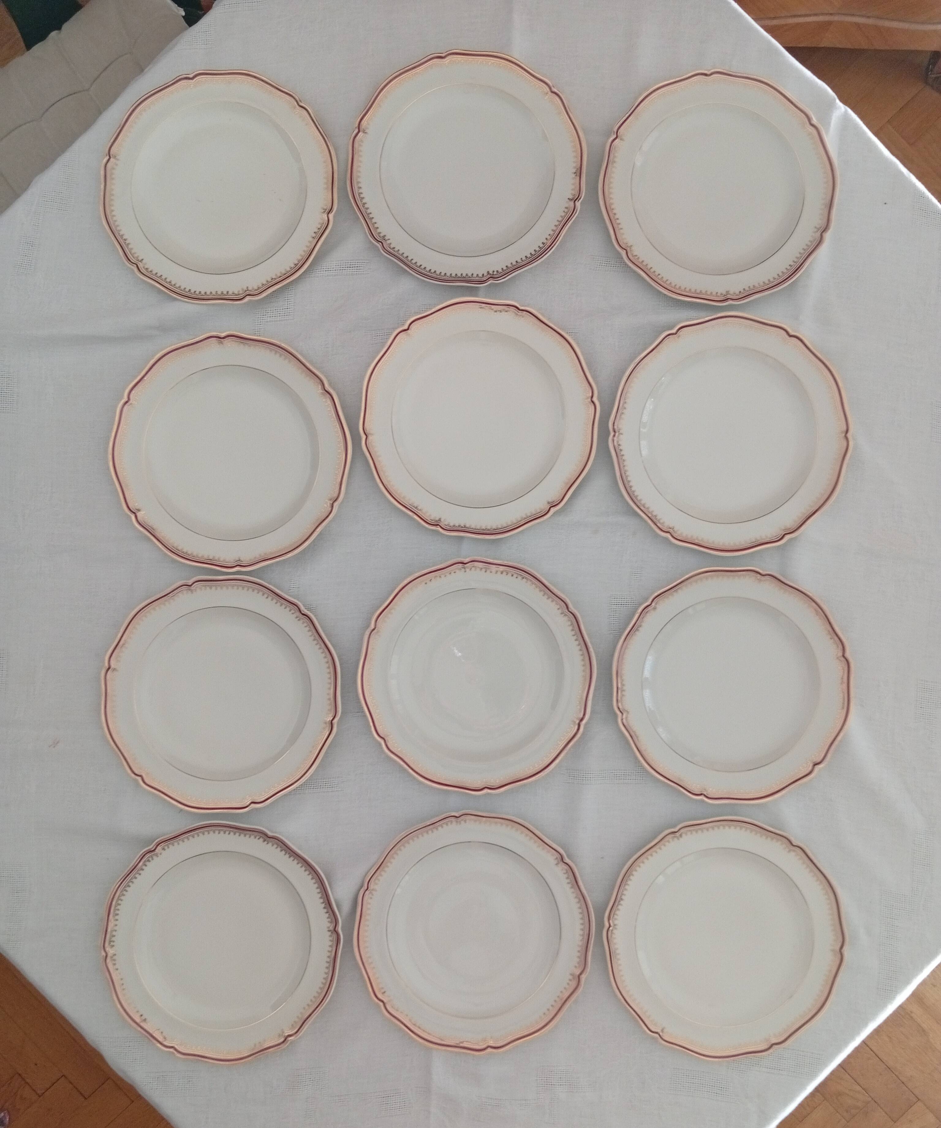 Set of 12 stylised white porcelain dinner plates, signed.