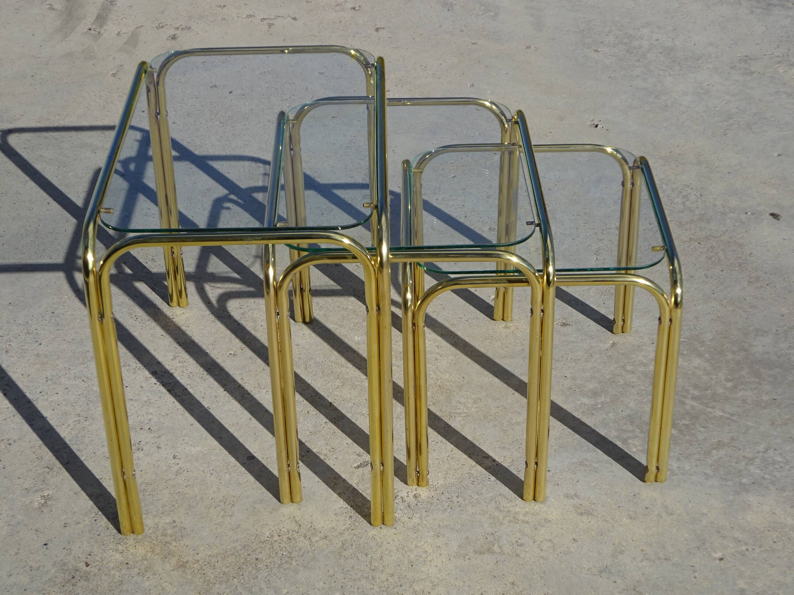 Nested tubular tables in gold metal.