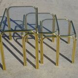 Nested tubular tables in gold metal.