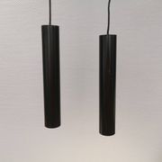 Two cylinder-shaped hanging lamps in black lacquer