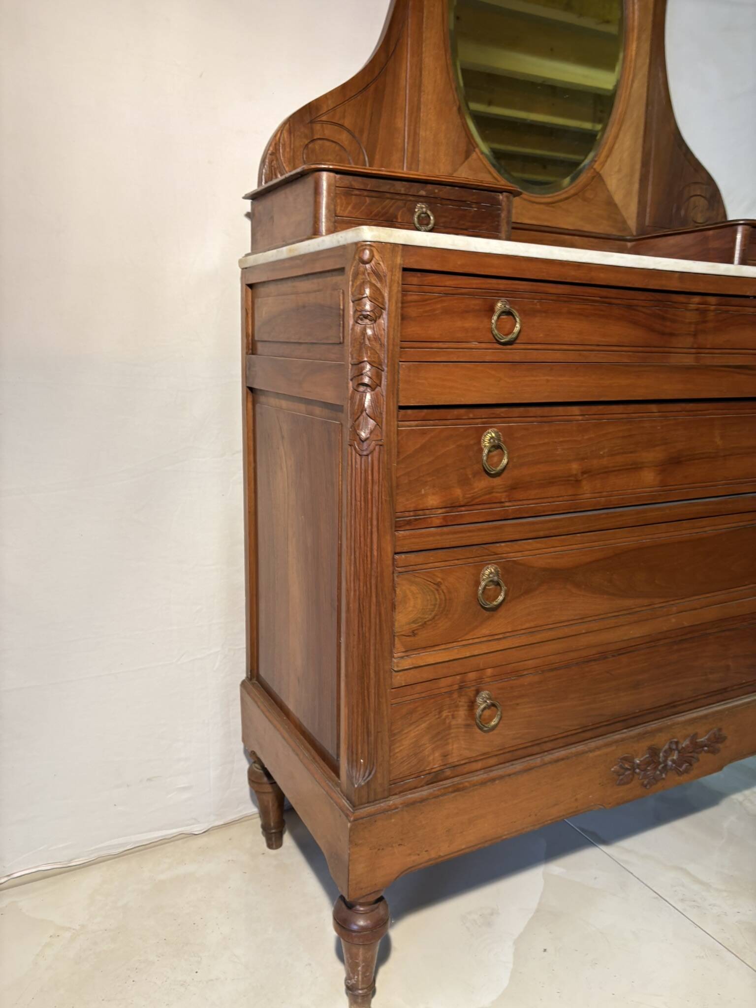 Antique carved wooden dressing table with marble and tilting oval mirror.