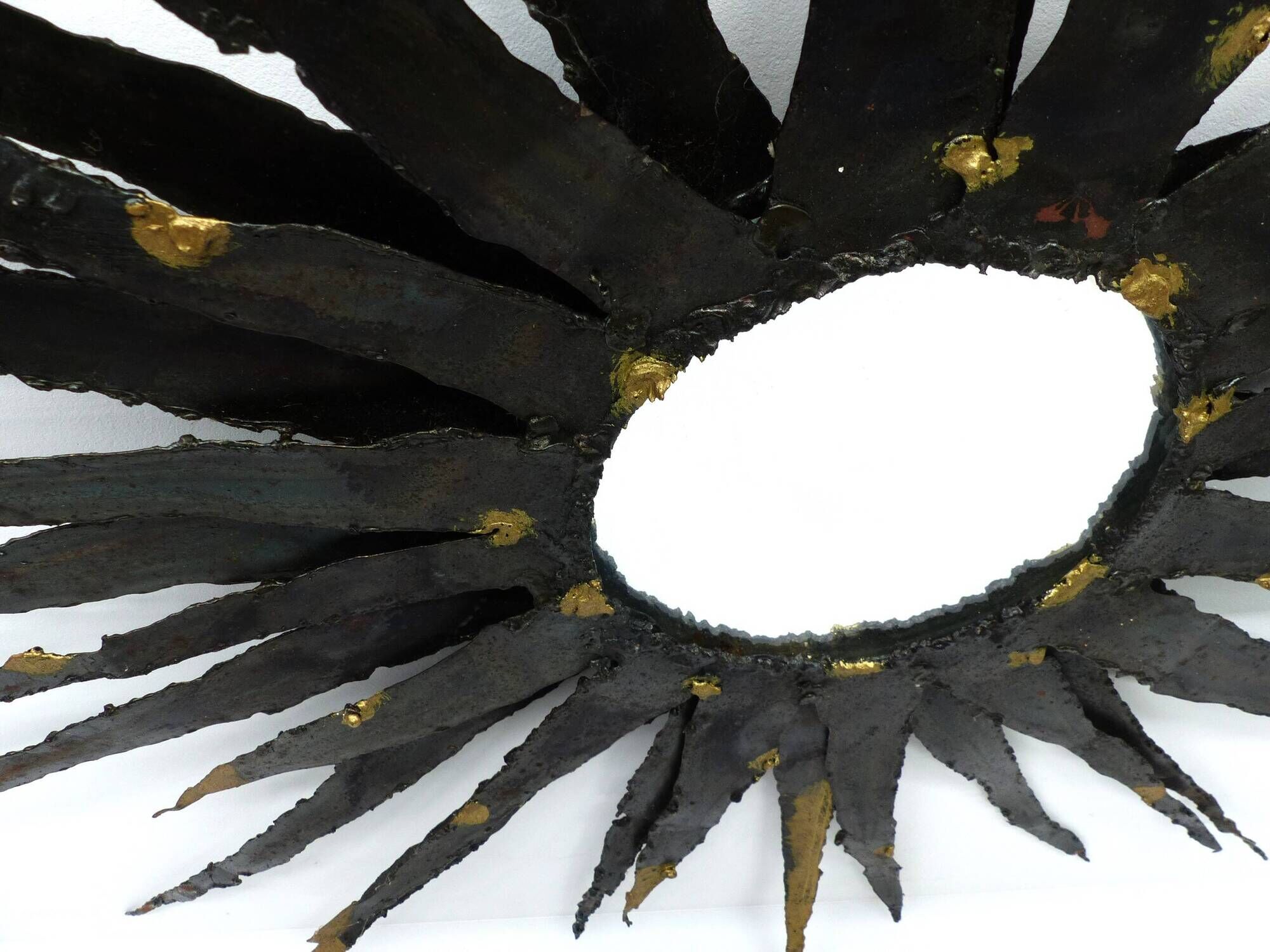 Large brutalist sun mirror in patinated metal with gold accents, 1970.