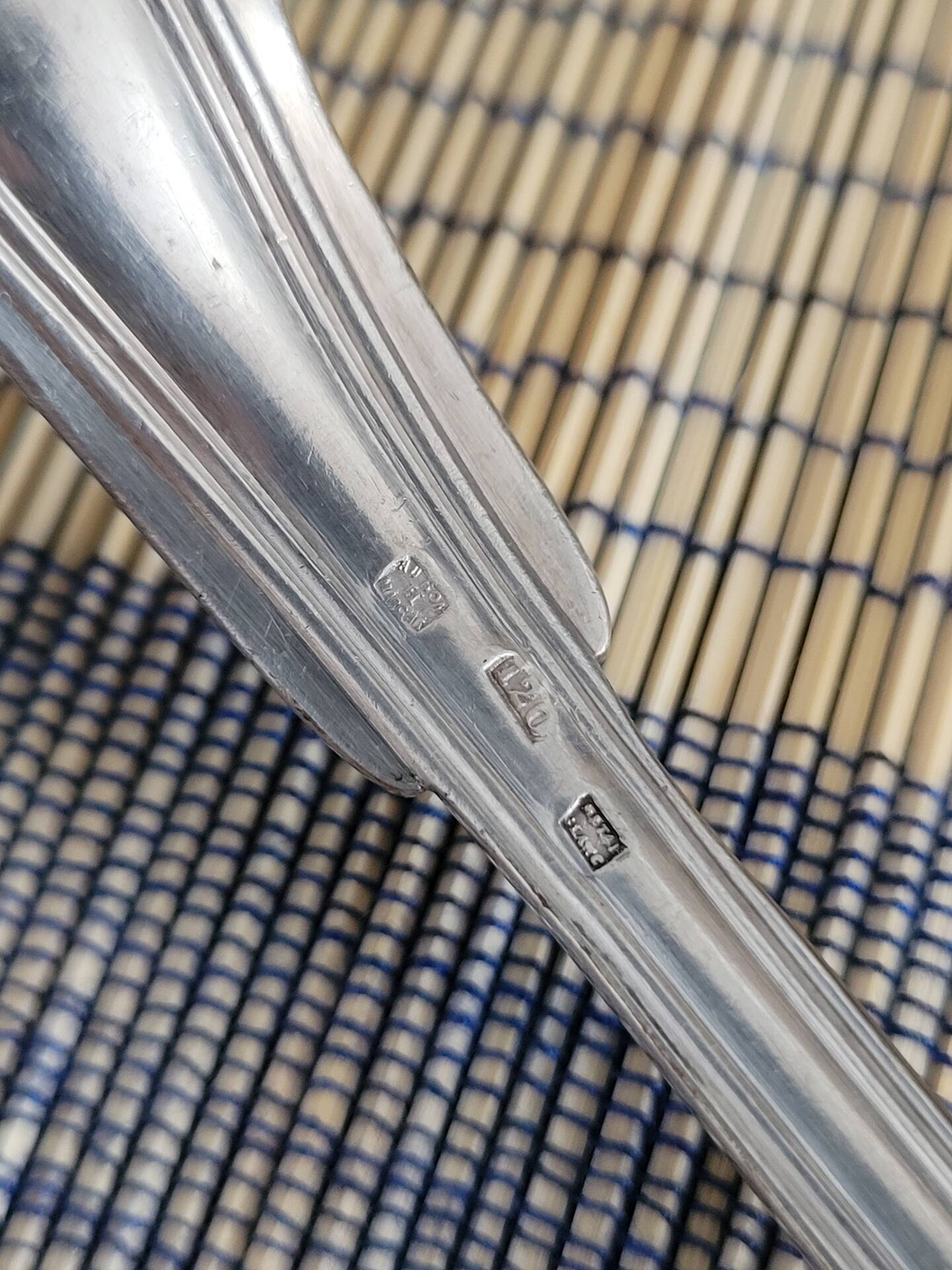 Large silver spoon with net decoration.