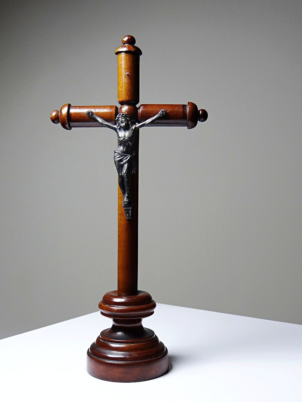 Antique wooden altar crucifix with a turned design and silver-plated Christ.