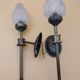 Pair of brass torch wall lights with globe flame.