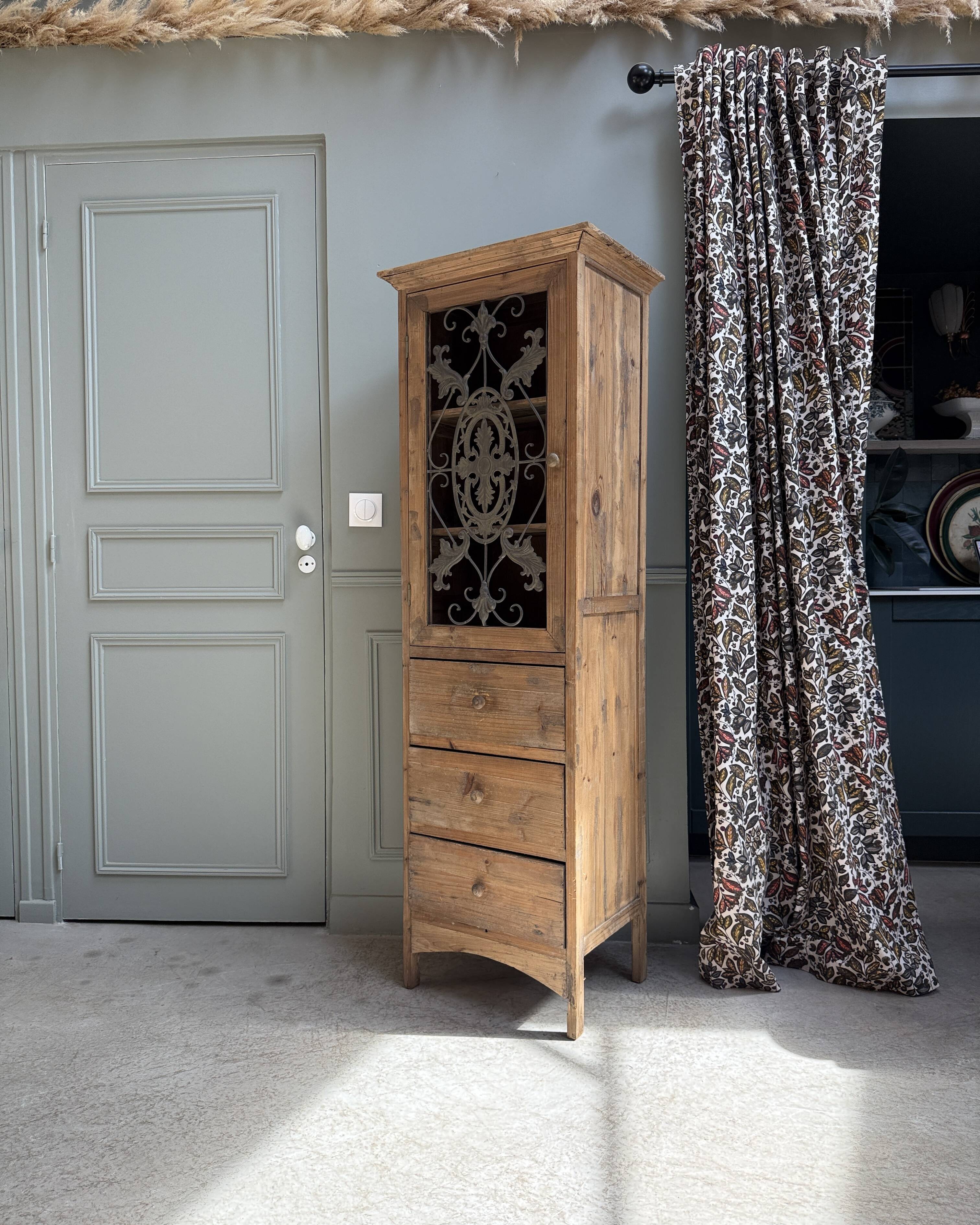 Column storage unit with a sculpted metal door.