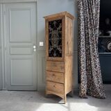 Column storage unit with a sculpted metal door.