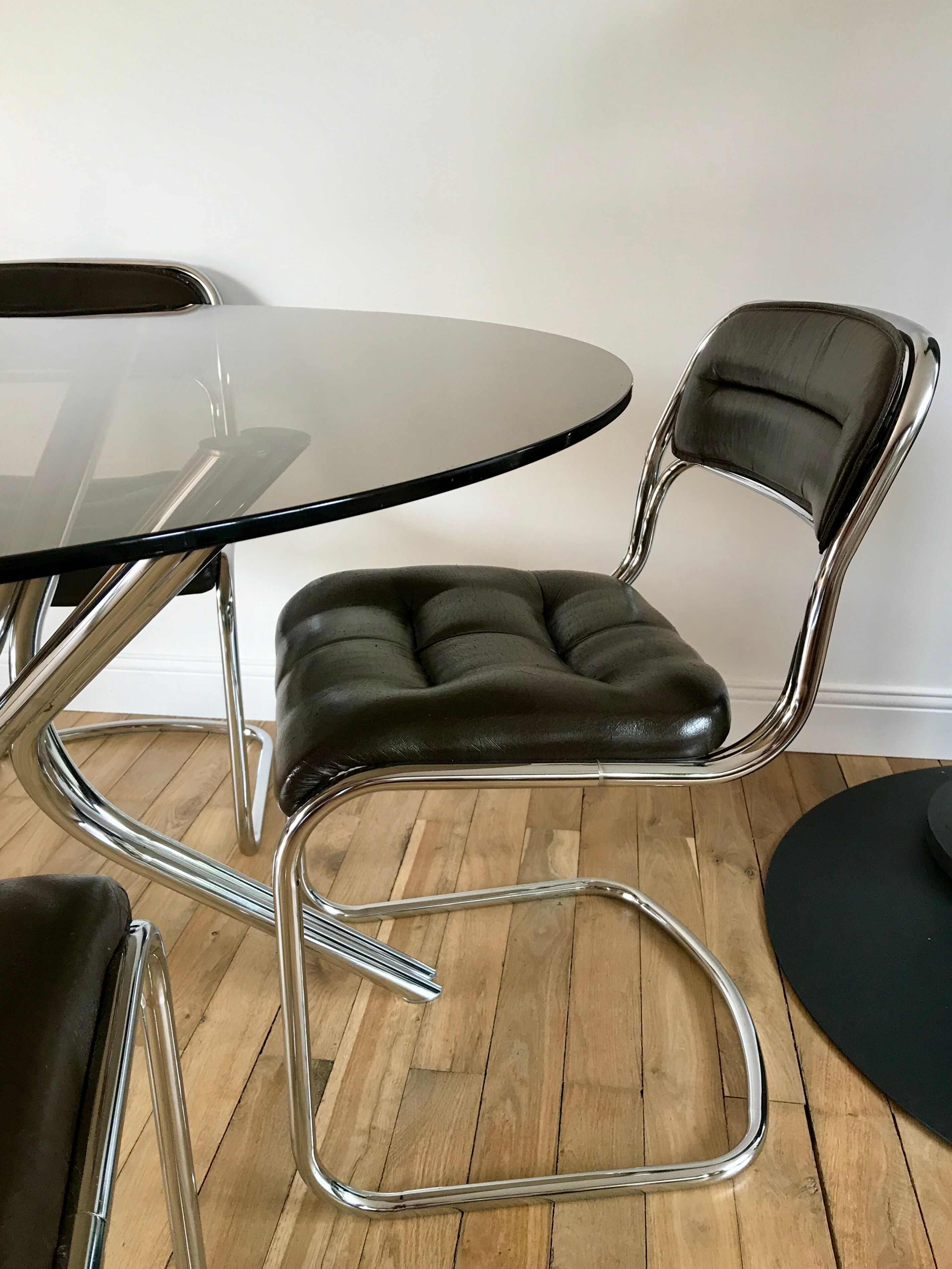 Set consisting of a table in chrome and smoked glass and its 4 tubular chairs in chrome and skaï a