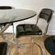 Set consisting of a table in chrome and smoked glass and its 4 tubular chairs in chrome and skaï a
