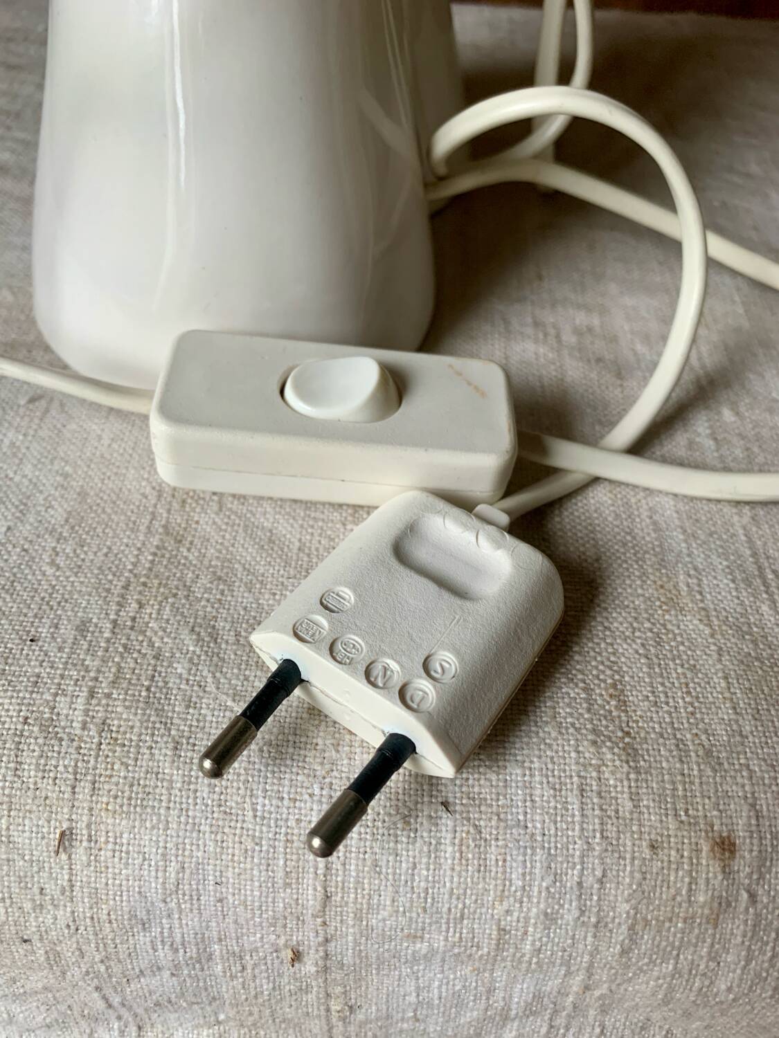 Ceramic table lamp depicting two hands holding a globe, 1980