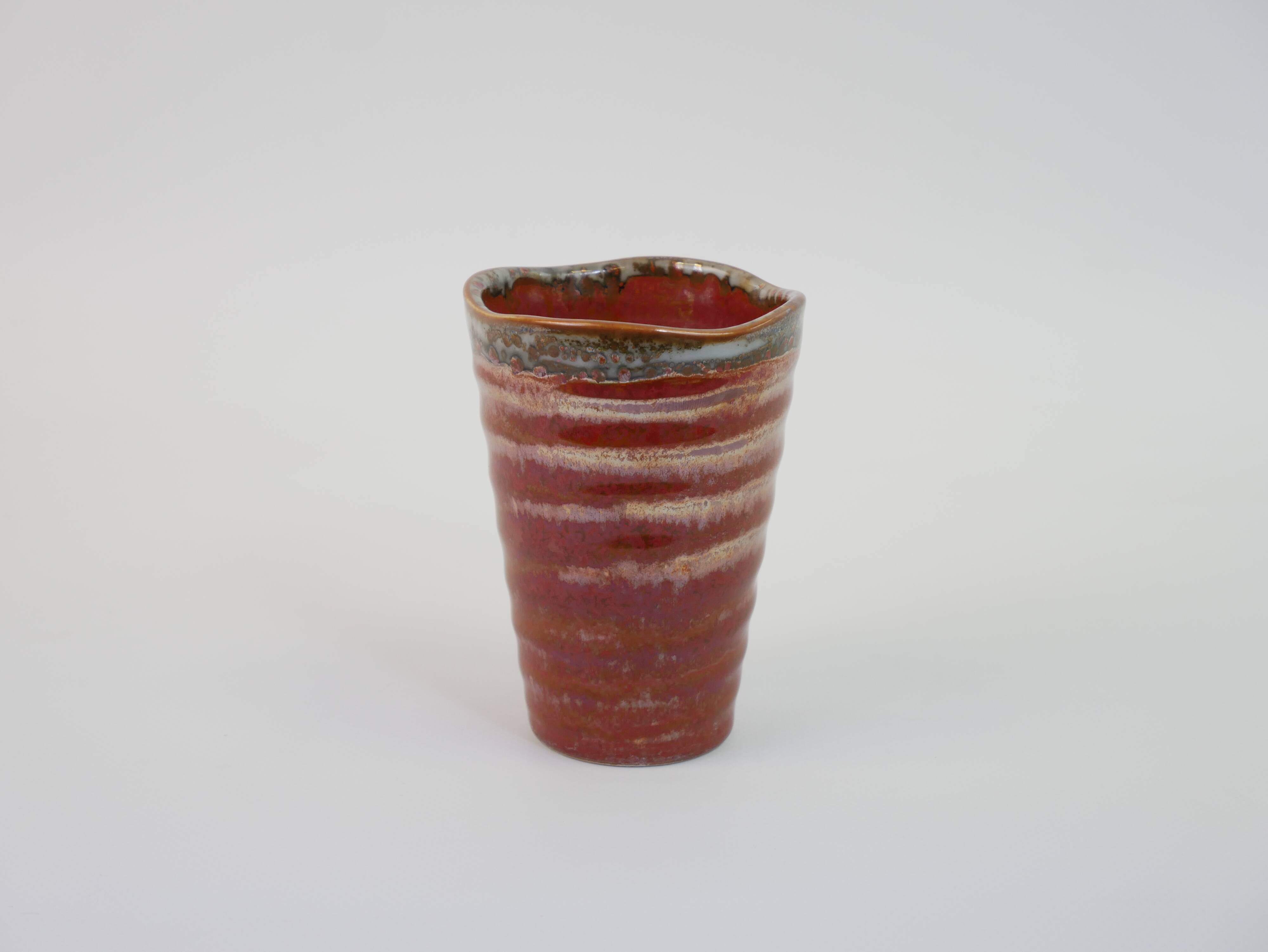 Small orange glazed ceramic cup