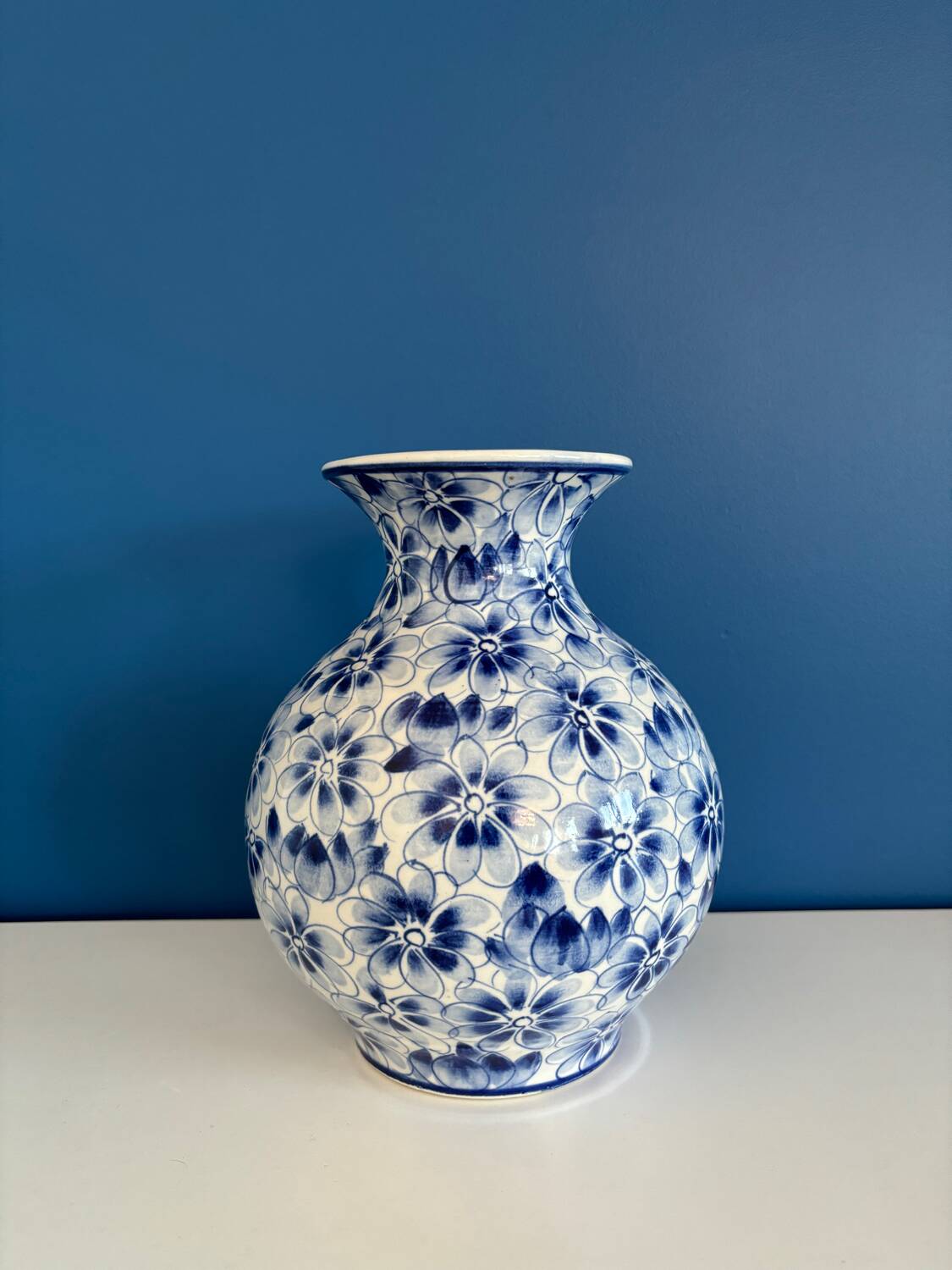 Blue and white ceramic vase with floral pattern in the shape of a vintage ball