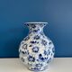 Blue and white ceramic vase with floral pattern in the shape of a vintage ball