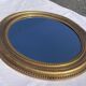 Duo de miroirs ovales et dorés en bois