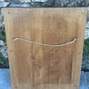 Miroir Baroque en bois doré sur fond noir.