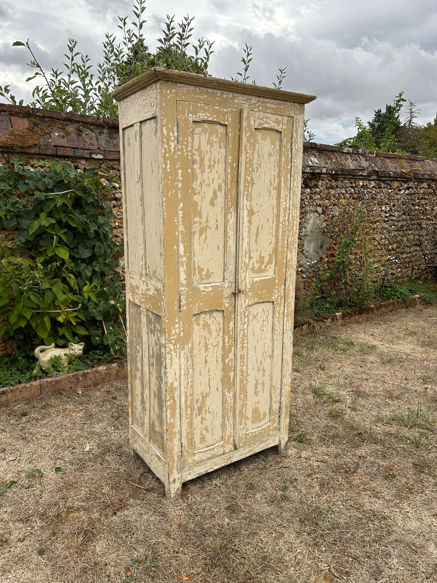 Small antique wardrobe with a faded white patina.
