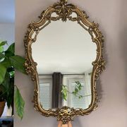 Rocaille style mirror from the 20th century in wood and gilded stucco, Putto on the pediment