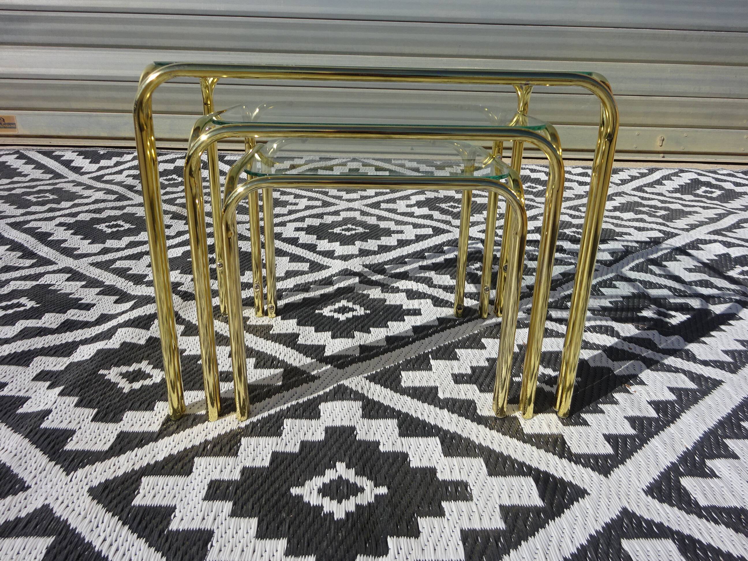 Nested tubular tables in gold metal.