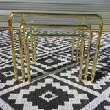 Nested tubular tables in gold metal.