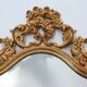 French Rococo or Baroque style facet-cut crest mirror in gilded carved wood