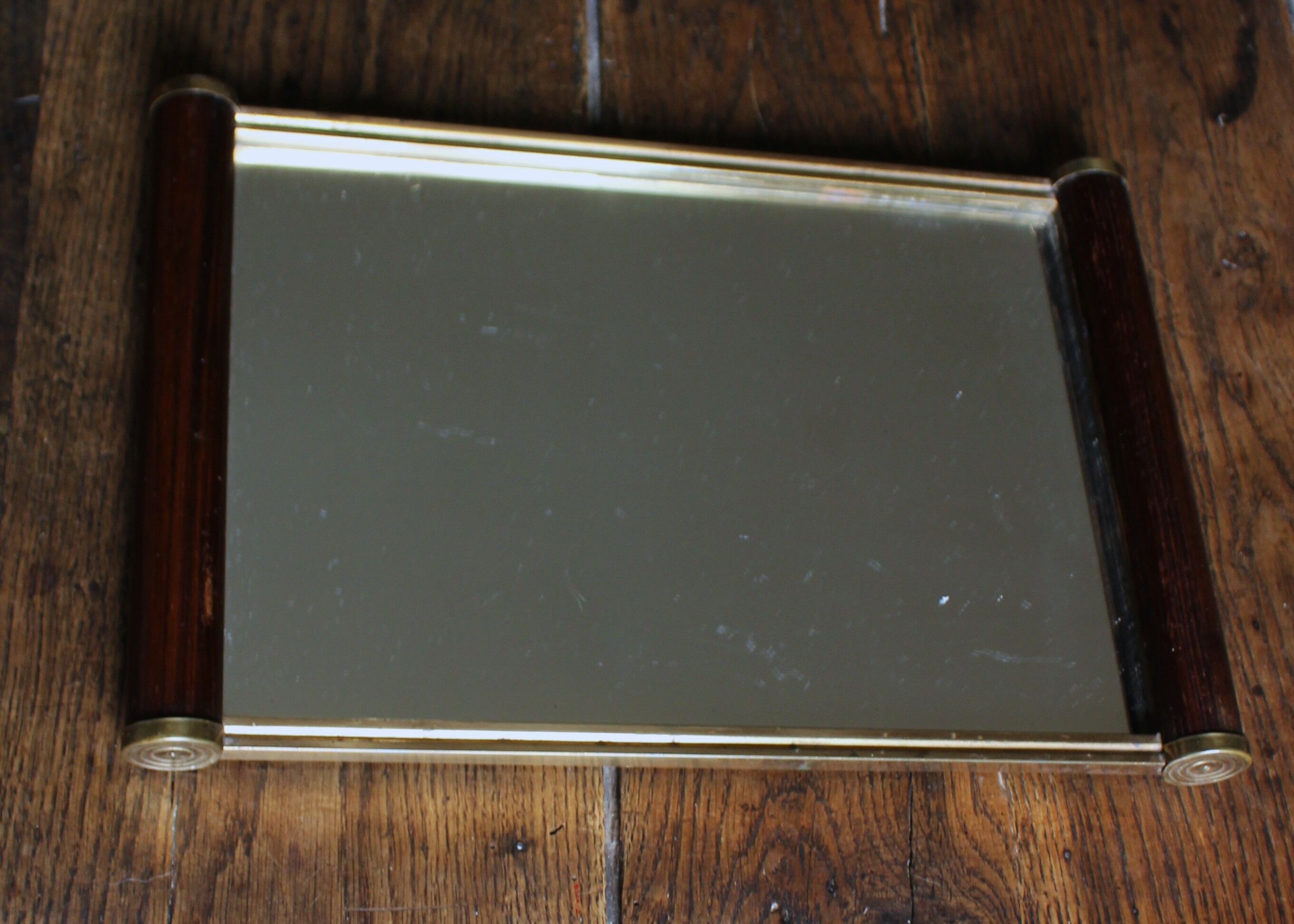 Rectangular mirror tray with wooden handles and gilding.