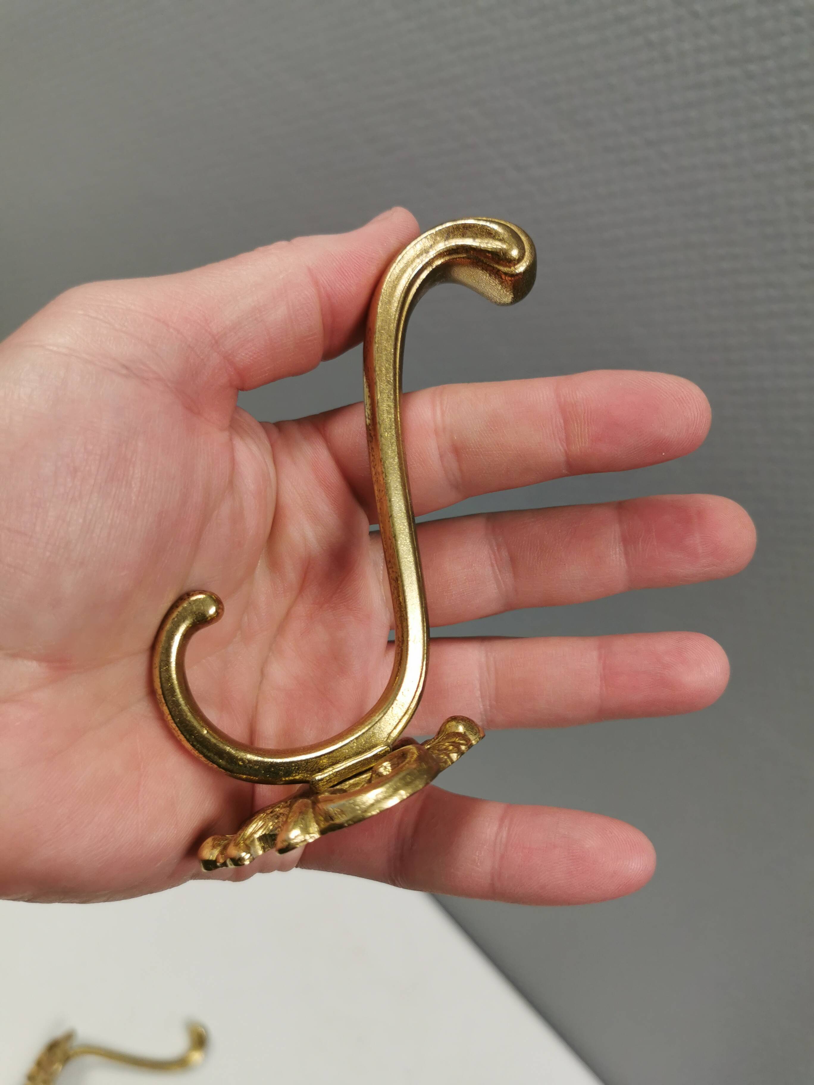 Three old and beautiful brass hooks with decorative motifs