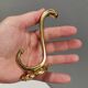 Three old and beautiful brass hooks with decorative motifs