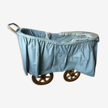 Old wooden cradle and wicker on wheels