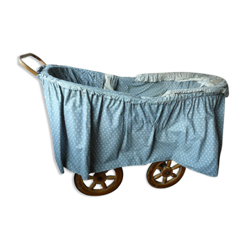 Old wooden cradle and wicker on wheels