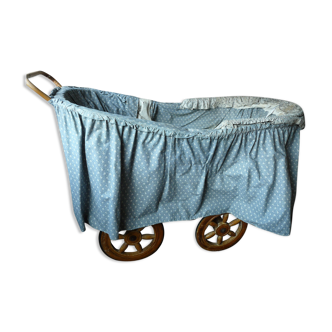 Old wooden cradle and wicker on wheels