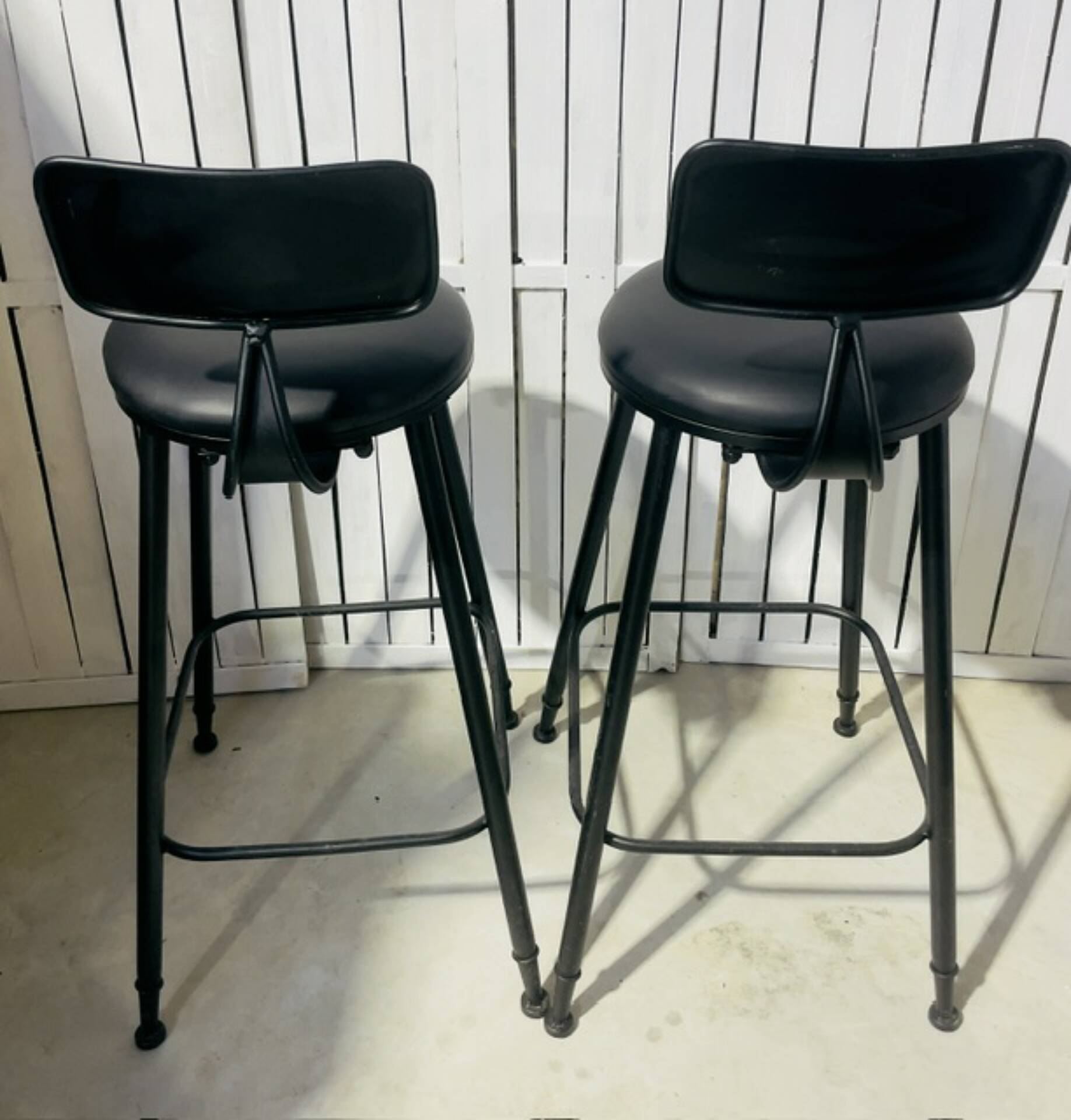 Pair of black bar stools in industrial and contemporary style.