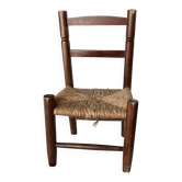 Vintage children's chair in dark wood with woven straw seat