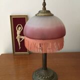 Old table/bedside lamp with glass shade with pink gradients and fringes.