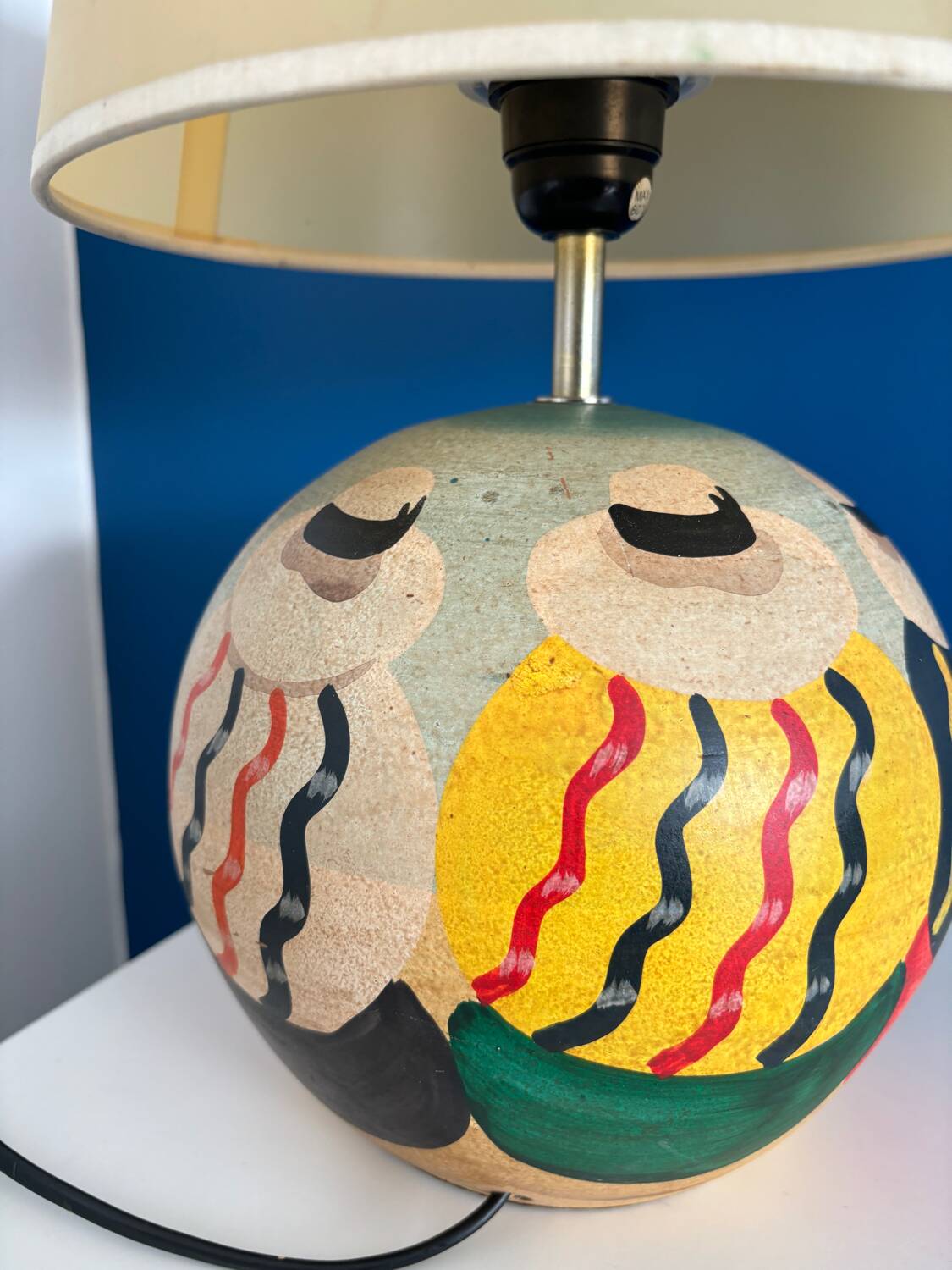 Ceramic table lamp representing women in hats on the sand.