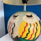 Ceramic table lamp representing women in hats on the sand.