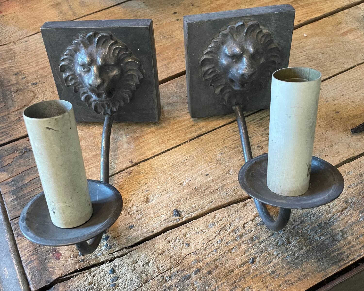 Two lion head wall sconces in tin.