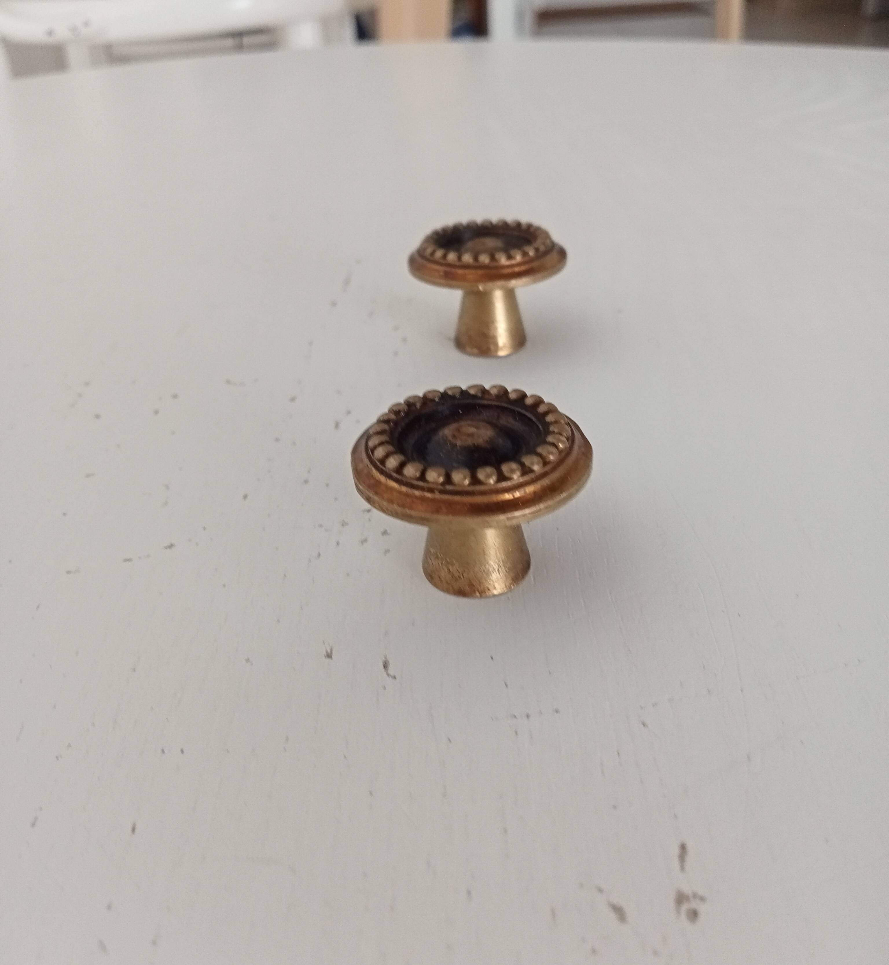 Pair of antique furniture knobs in gilded brass.