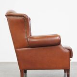Correct, comfortable, luxurious English-style wingback armchair made of cognac-colored cow leather