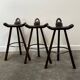 Set of 3 rustic carved oak bar stools with iron footrests, 1970s